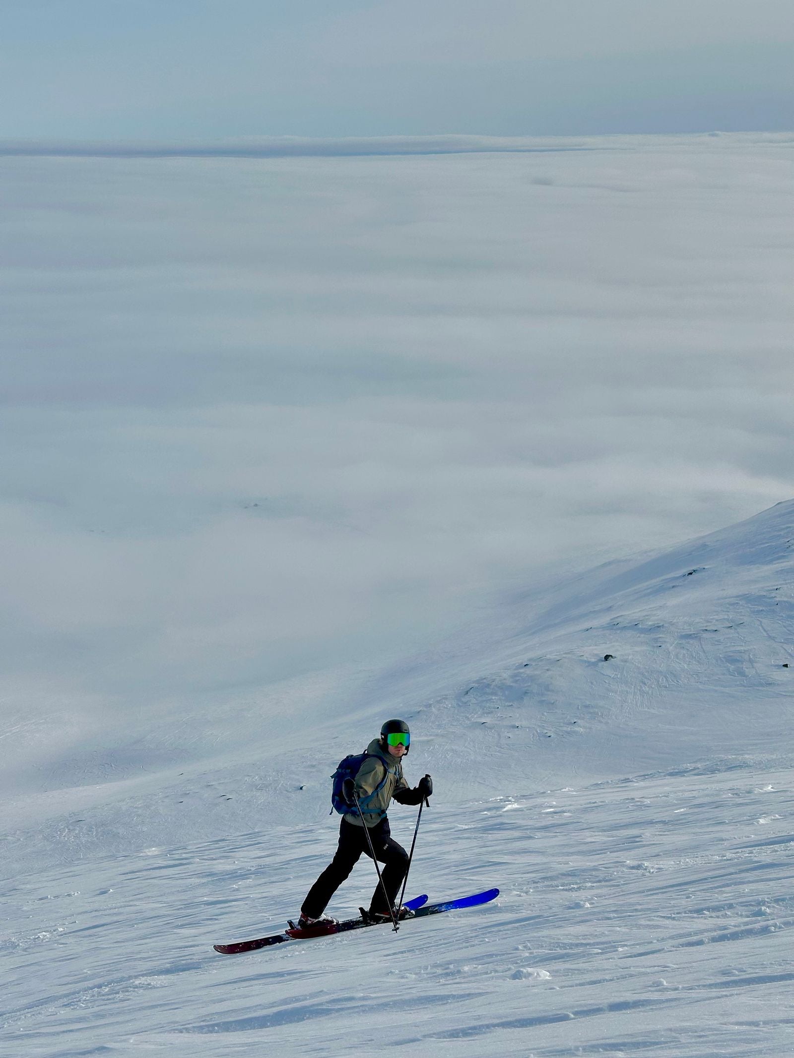 Ski de randonnée au-dessus d'une mer de nuages, sommets enneigés