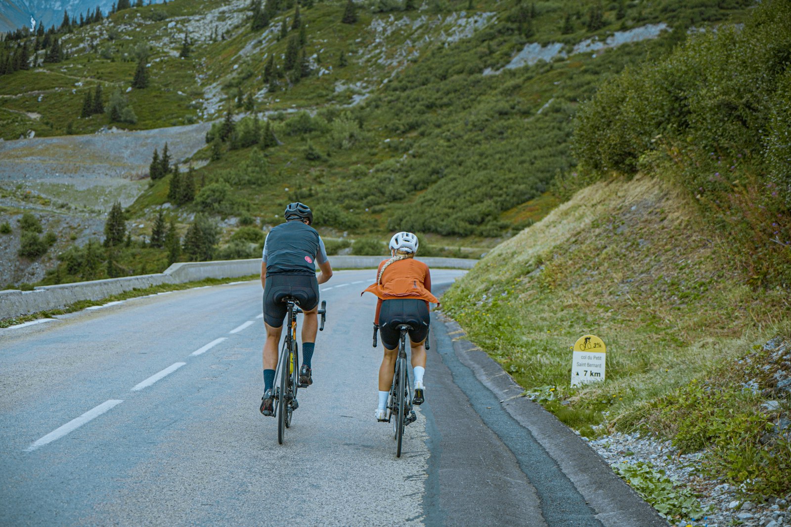 Duo de cyclistes dans la montée d'un col alpin (photo Unsplash)